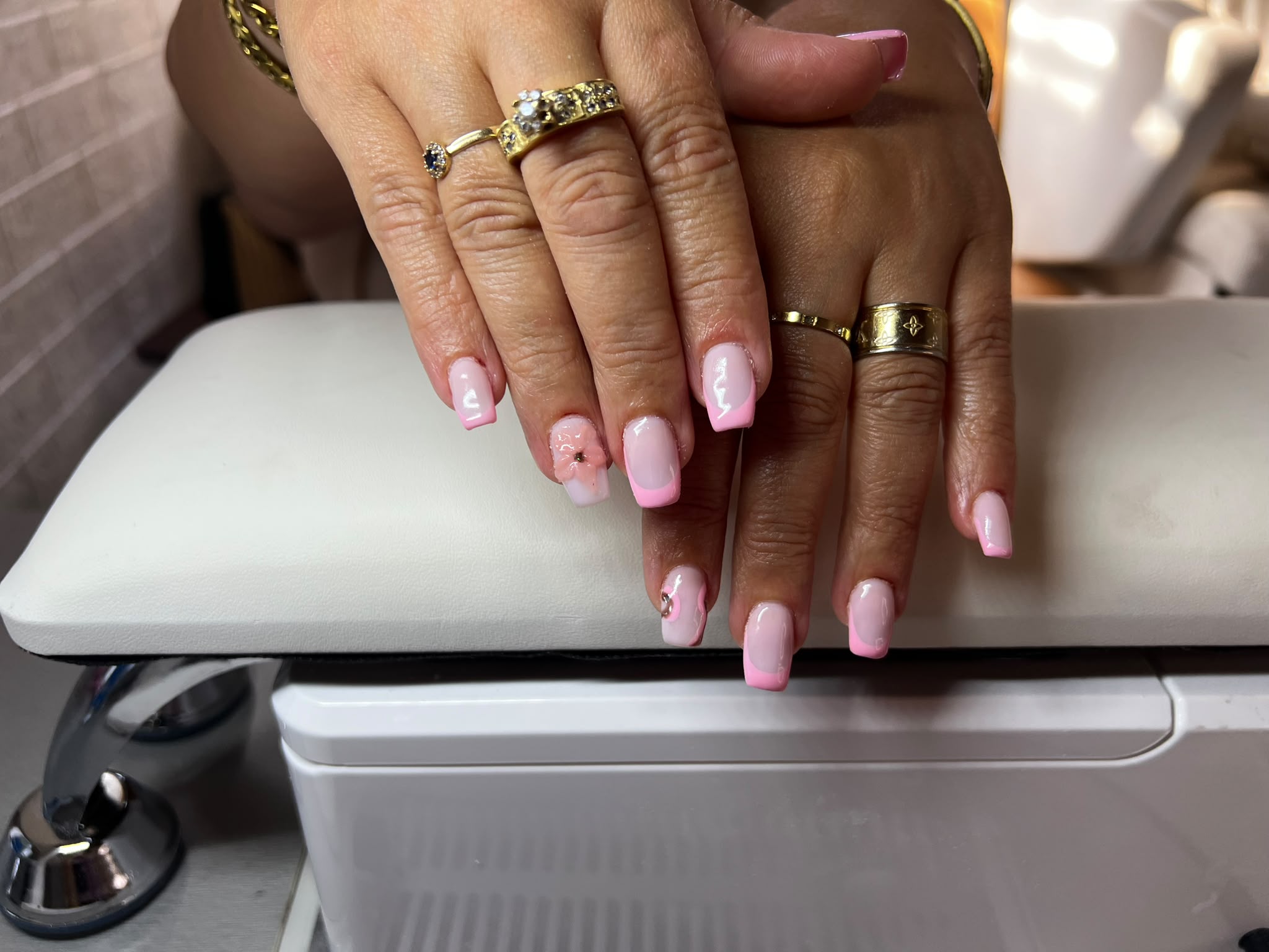 Roze nagels met kleine accenten, handen op de armleuning