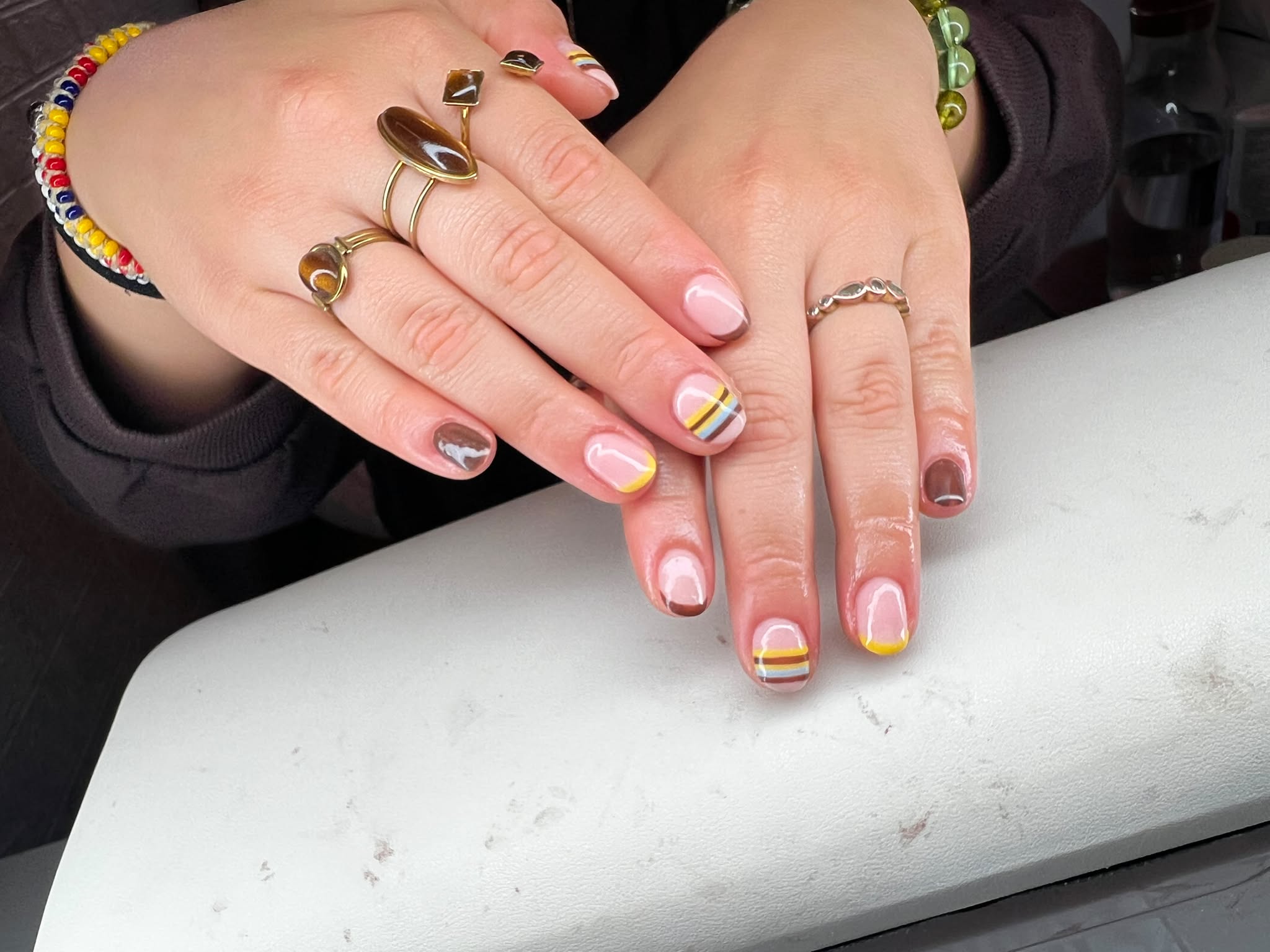 Lichte nagels met strepen en accenten in geel en bruin